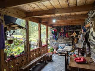 Een gezellige houten veranda in een Georgisch dorp, versierd met kleurrijke handwerken.